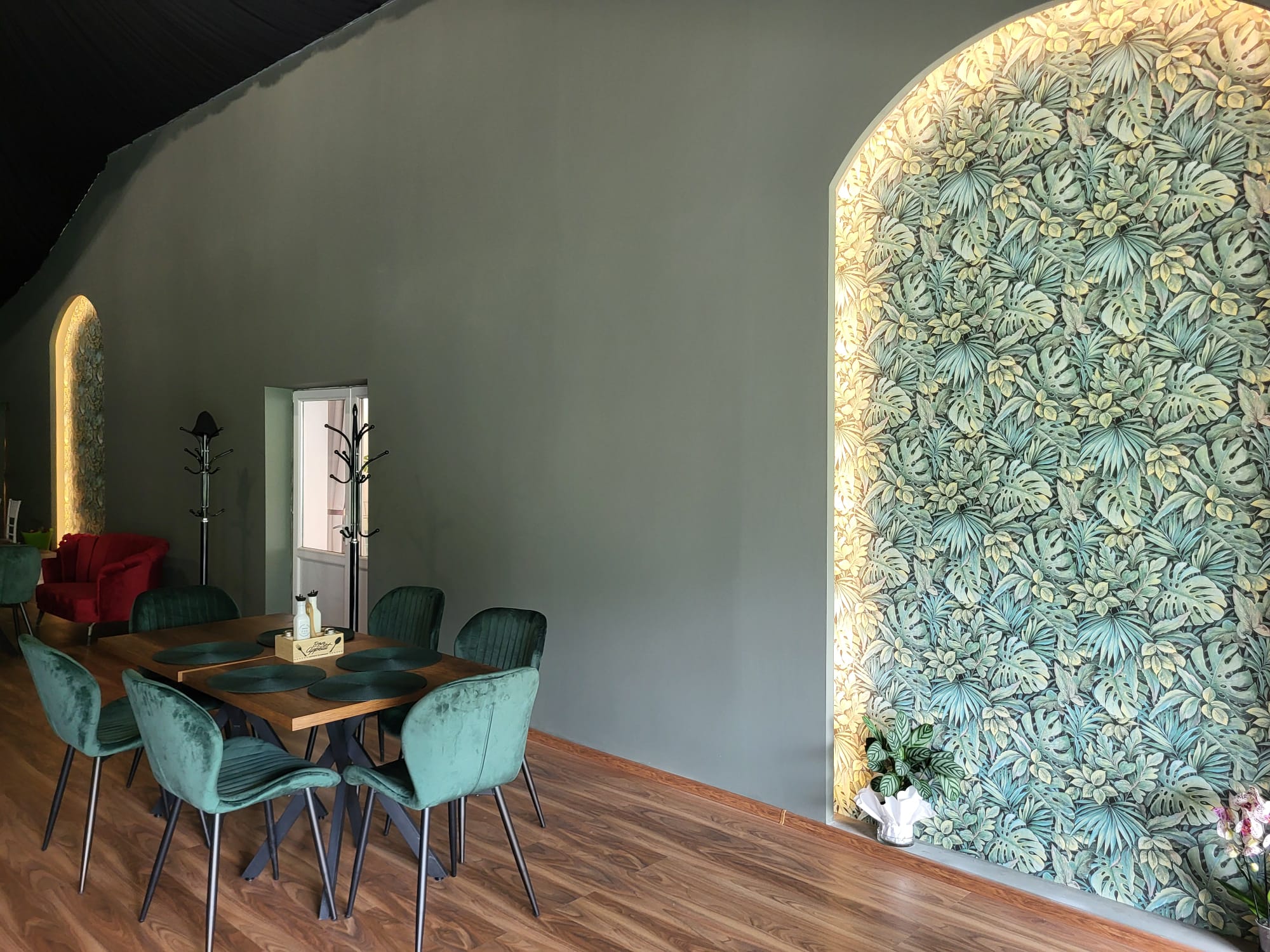 Sală restaurant cu perete vegetal și arcadă luminată